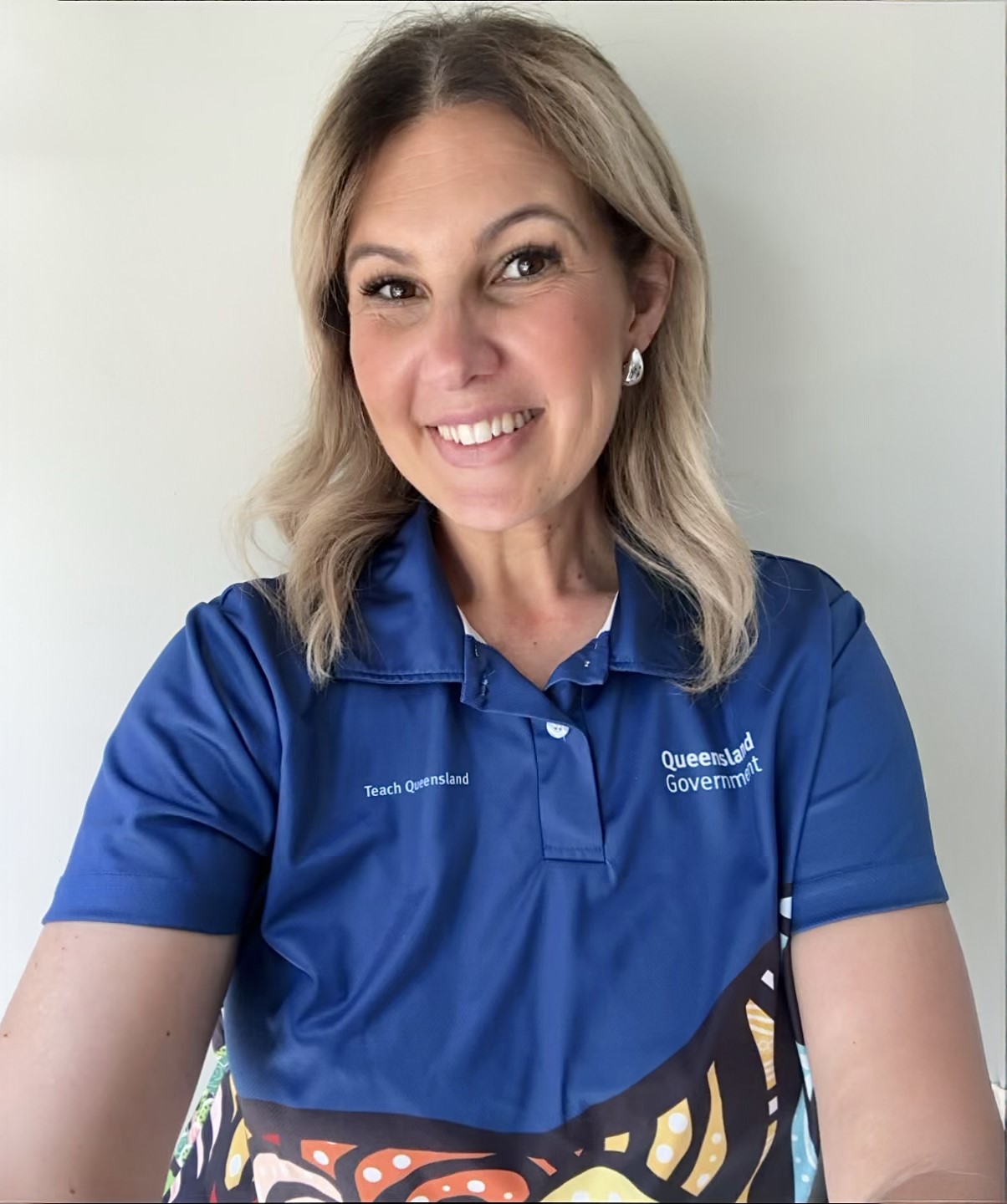 Photo of a female recruiter with blonde hair. She is smiling at the camera and wears a blue shirt.