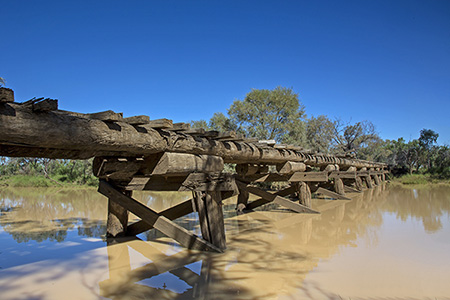 Sunset at Lara wetlands and camping grounds in outback Western Queensland, Australia with drowned trees and reflections caused by artesian bore runoff.