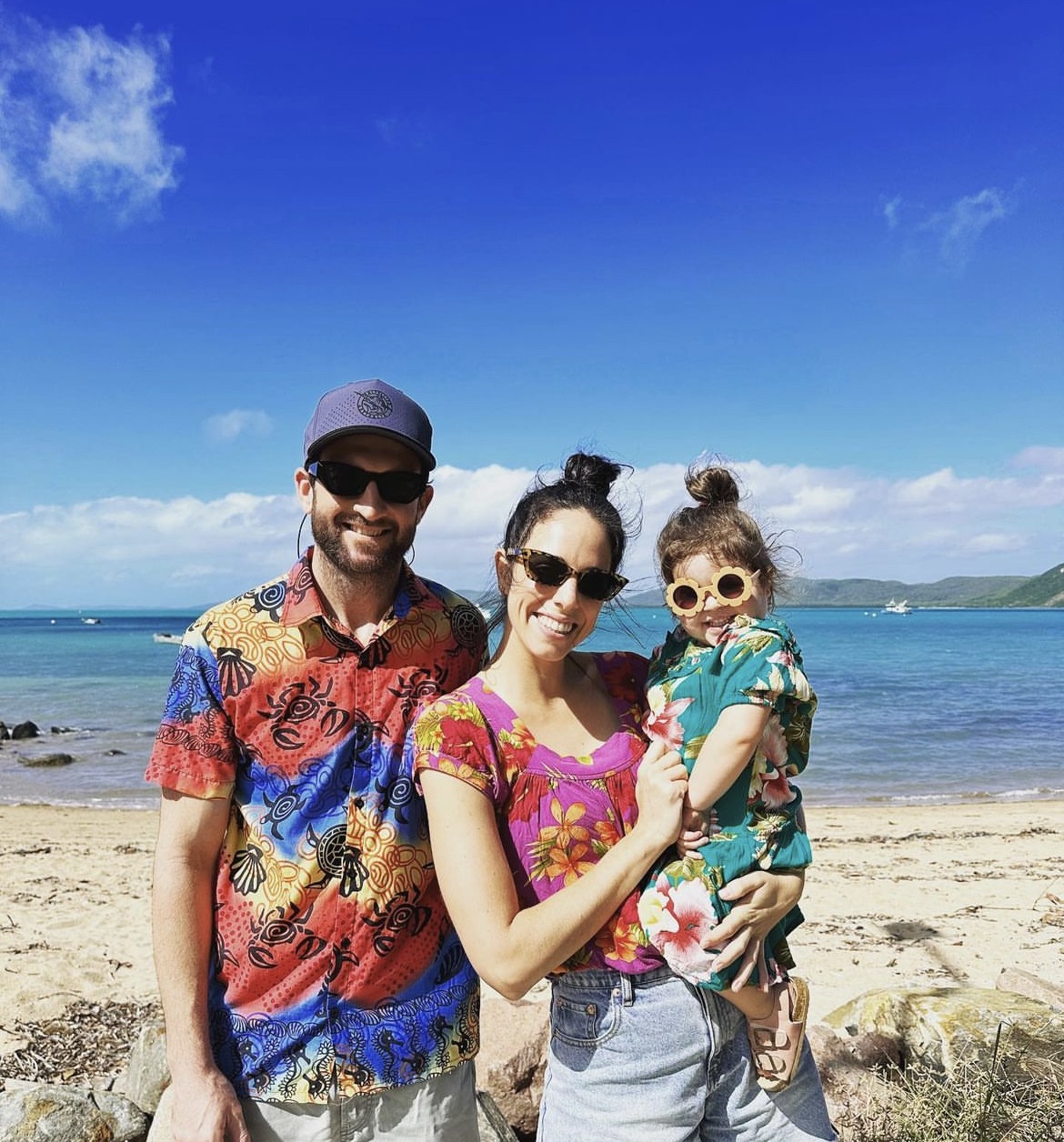 Cameron and his family standing on a beach.