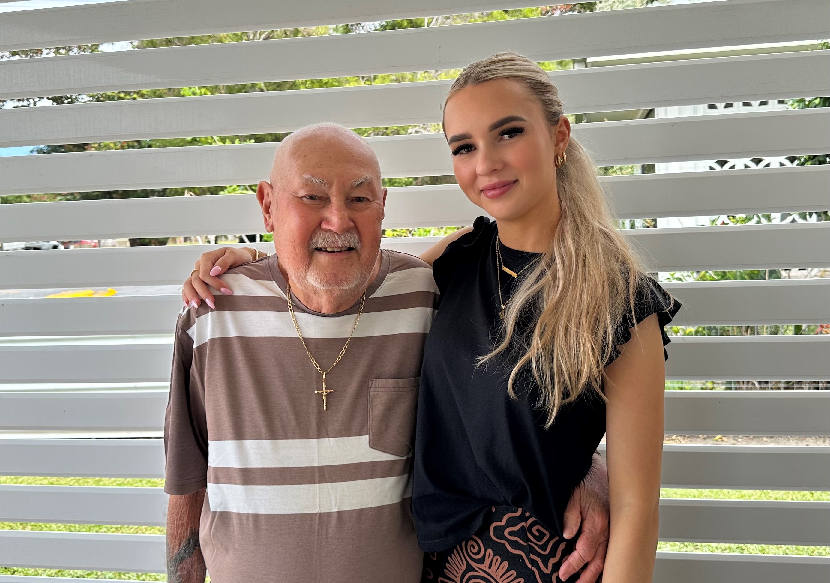 Holly and her grandfather hugging and smiling at the camera.