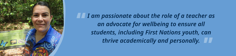 A female preservice teacher smiling at the camera, with tan skin and dark hair, in a blue shirt, standing in a rainforest.